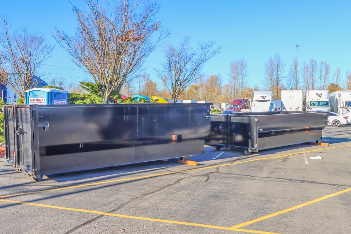 Professional dumpster rental service with roll-off container on residential driveway in San Marcos